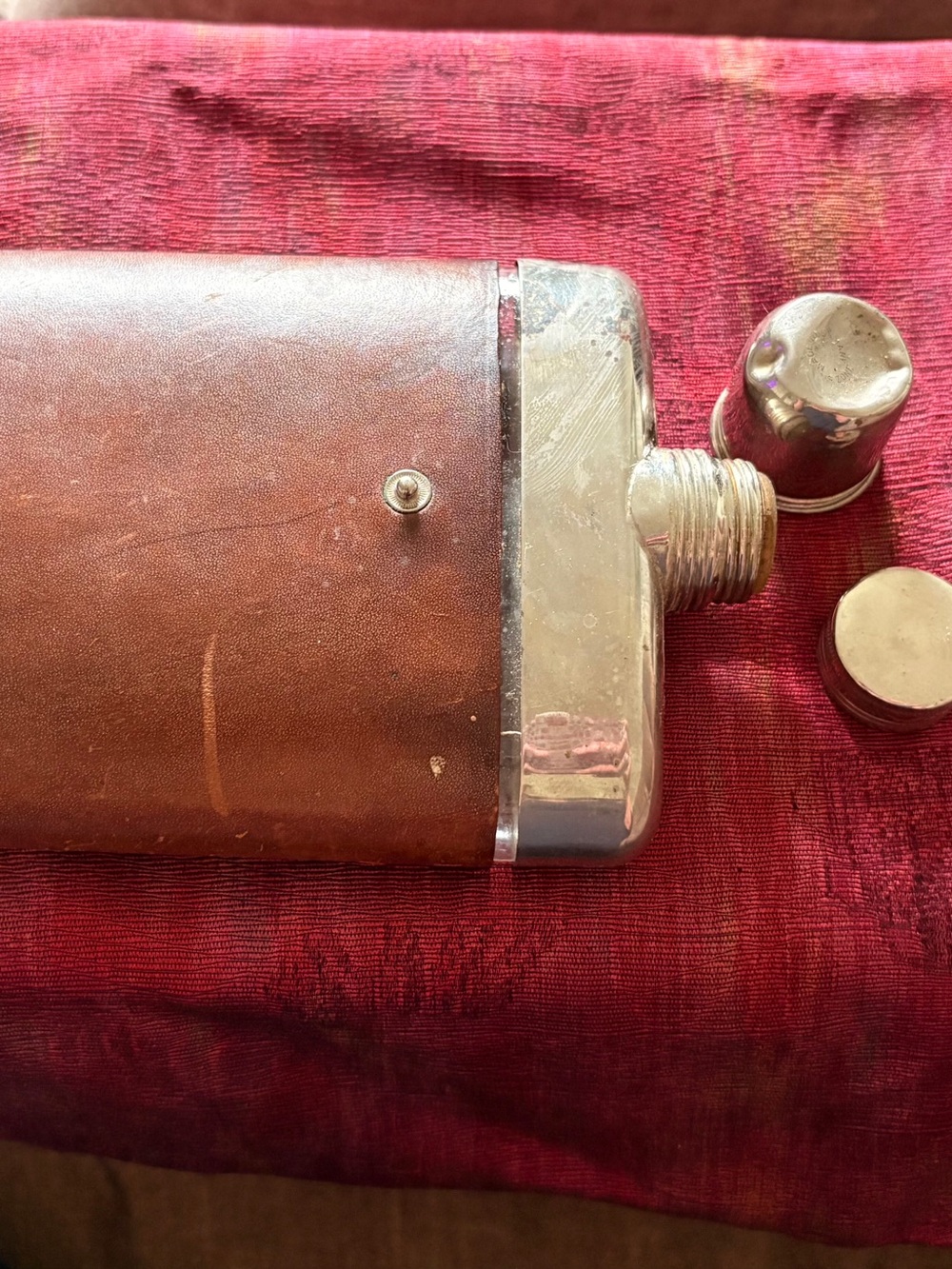 A Vintage hip flask. Glass bottle inside leather or like.